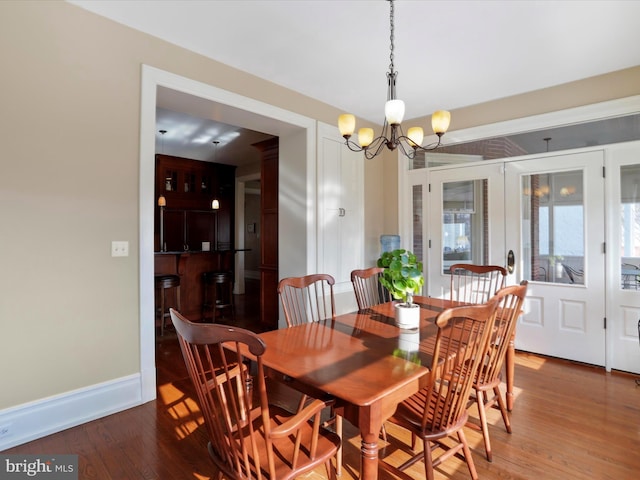 dining area featuring an inviting chandelier and dark wood-type flooring