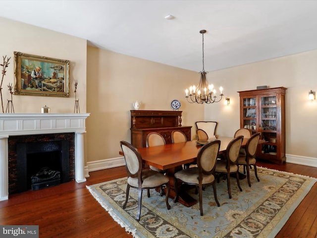 dining area featuring a premium fireplace, an inviting chandelier, and dark hardwood / wood-style flooring