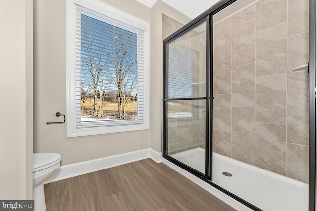 bathroom featuring wood-type flooring, toilet, and walk in shower