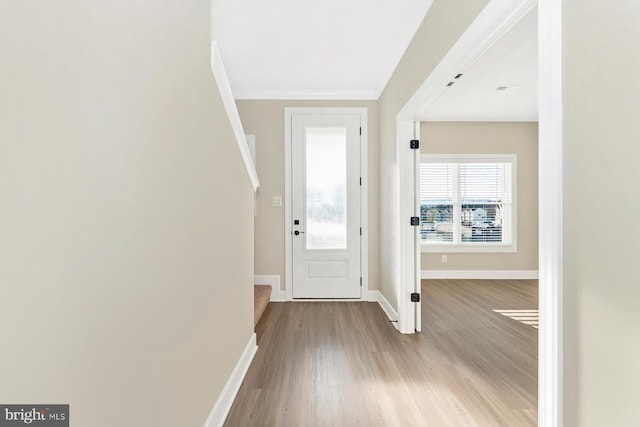 entryway with light hardwood / wood-style floors and ornamental molding