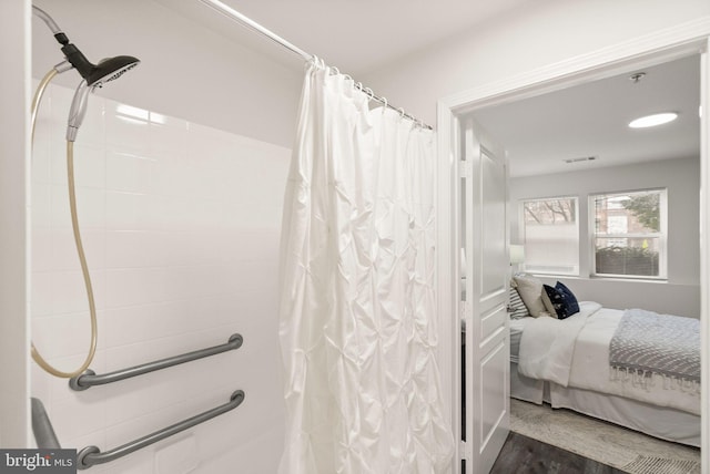 bathroom featuring curtained shower and hardwood / wood-style flooring