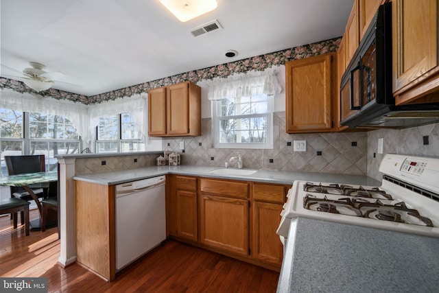 kitchen featuring sink, white appliances, ceiling fan, dark hardwood / wood-style floors, and tasteful backsplash