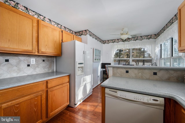 kitchen with dark wood-type flooring, white appliances, ceiling fan, and decorative backsplash