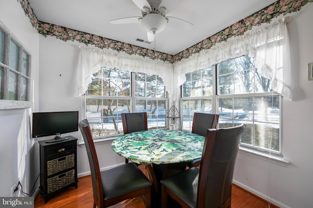 dining space featuring wood-type flooring and ceiling fan