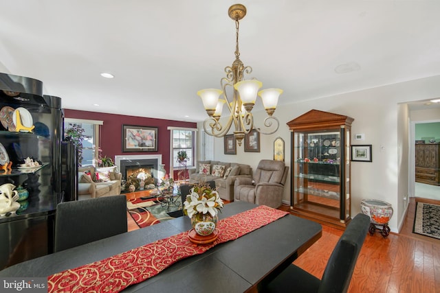 dining room with wood-type flooring, plenty of natural light, and a notable chandelier