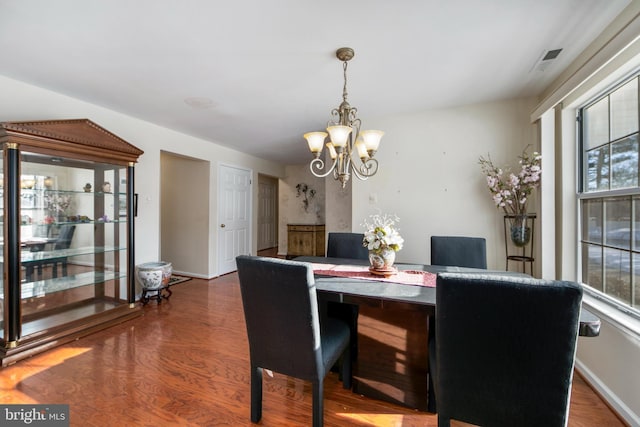 dining area with an inviting chandelier and hardwood / wood-style flooring