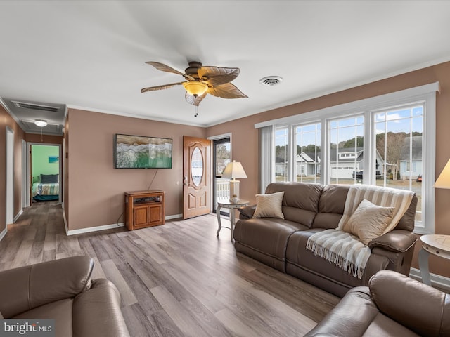 living room featuring light wood-type flooring, ceiling fan, and ornamental molding