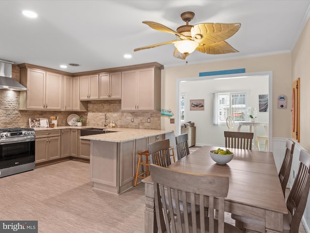 kitchen with tasteful backsplash, ornamental molding, kitchen peninsula, stainless steel gas stove, and light stone counters