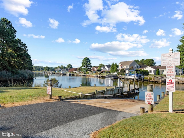 dock area with a lawn and a water view