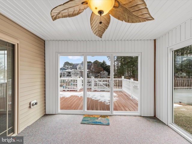 unfurnished sunroom featuring ceiling fan