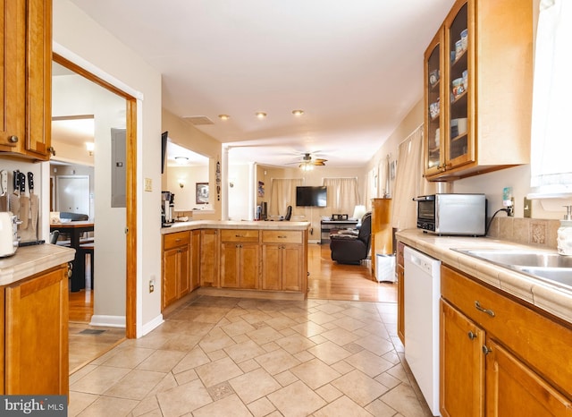 kitchen with ceiling fan, dishwasher, electric panel, tile counters, and kitchen peninsula