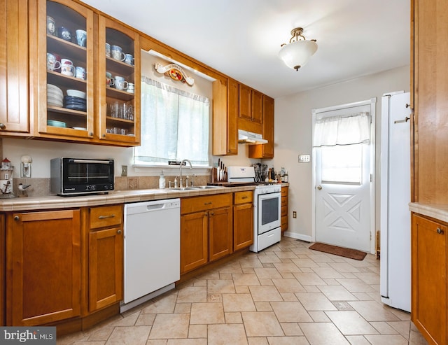 kitchen with a healthy amount of sunlight, sink, and white appliances