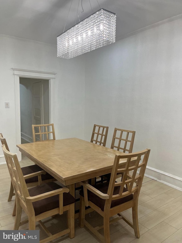 dining area with ornamental molding, a chandelier, and light wood-type flooring