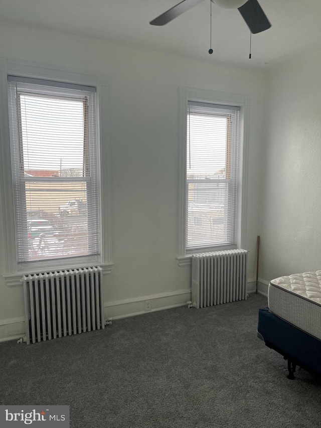 interior space featuring ceiling fan and radiator heating unit