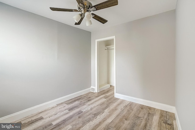 empty room with ceiling fan and light wood-type flooring