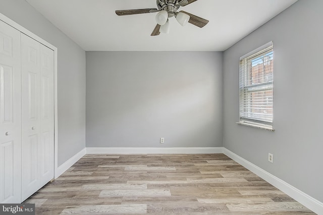 unfurnished bedroom featuring ceiling fan, light hardwood / wood-style floors, and a closet