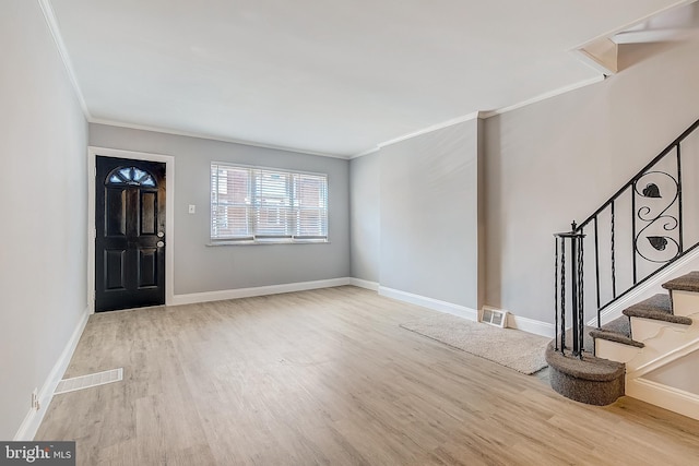 entrance foyer featuring ornamental molding and light wood-type flooring