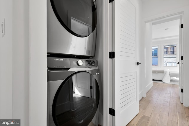 laundry area featuring light hardwood / wood-style flooring and stacked washer and dryer