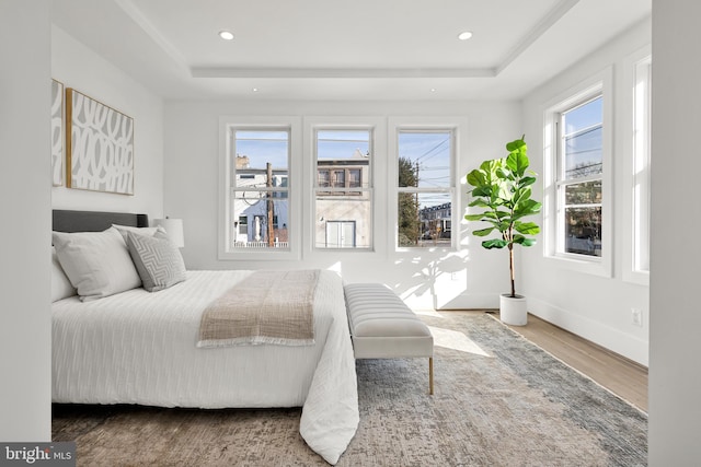 bedroom featuring hardwood / wood-style flooring and a tray ceiling