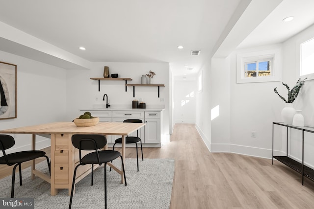 dining space with sink and light hardwood / wood-style floors