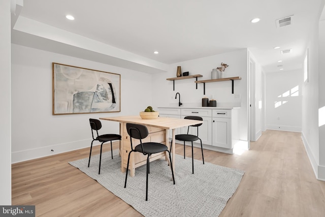 dining space with sink and light hardwood / wood-style floors