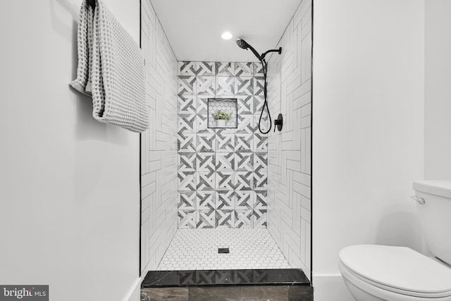 bathroom with toilet and tiled shower