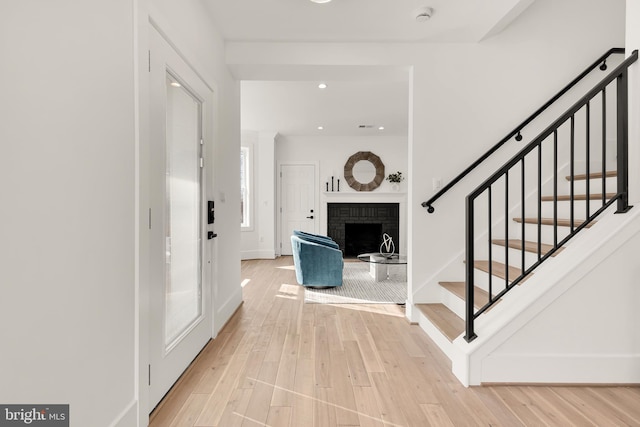 entrance foyer featuring a fireplace and light wood-type flooring