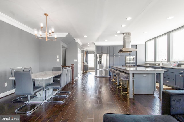 kitchen featuring a kitchen island, island exhaust hood, hanging light fixtures, and stainless steel refrigerator with ice dispenser