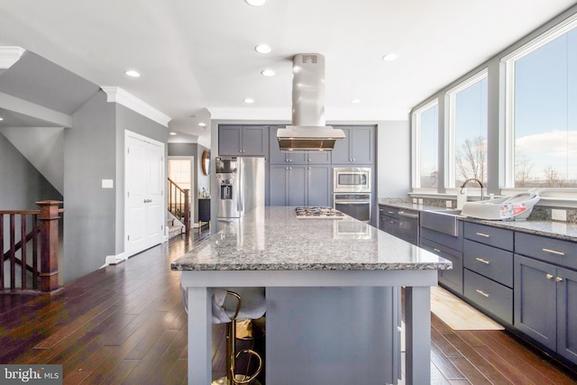 kitchen with a kitchen island, a breakfast bar area, island exhaust hood, and appliances with stainless steel finishes