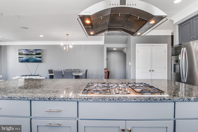 kitchen with dark stone countertops, island exhaust hood, gray cabinets, ornamental molding, and stainless steel appliances