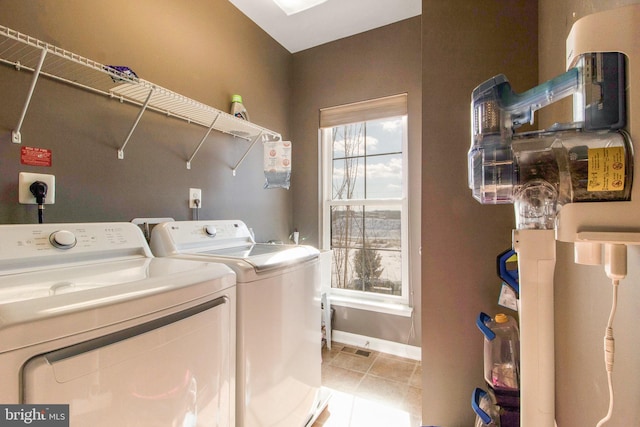 laundry area featuring washing machine and dryer and light tile patterned floors