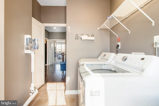 laundry area featuring washing machine and dryer and light tile patterned floors