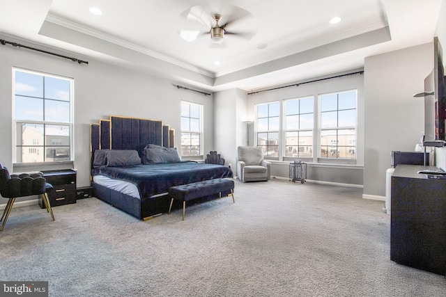 bedroom with ceiling fan, light carpet, a tray ceiling, and ornamental molding