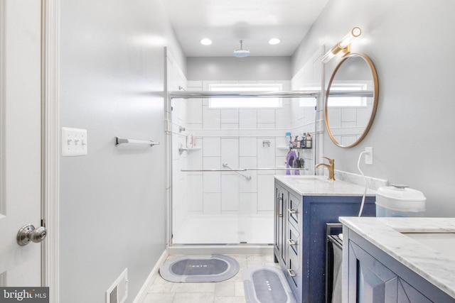 bathroom featuring tile patterned floors, a shower with door, and vanity