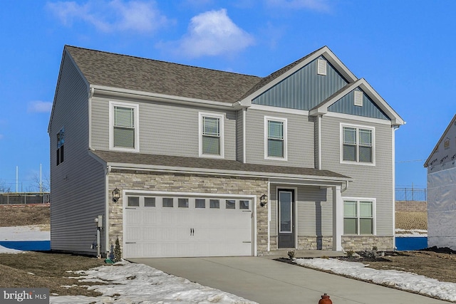 craftsman house featuring stone siding, concrete driveway, board and batten siding, and an attached garage