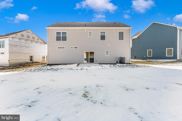 snow covered house featuring cooling unit