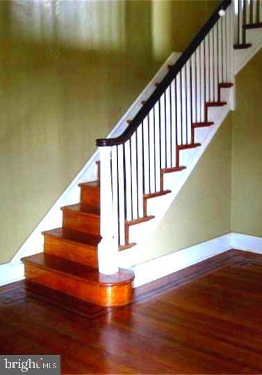 staircase with hardwood / wood-style floors