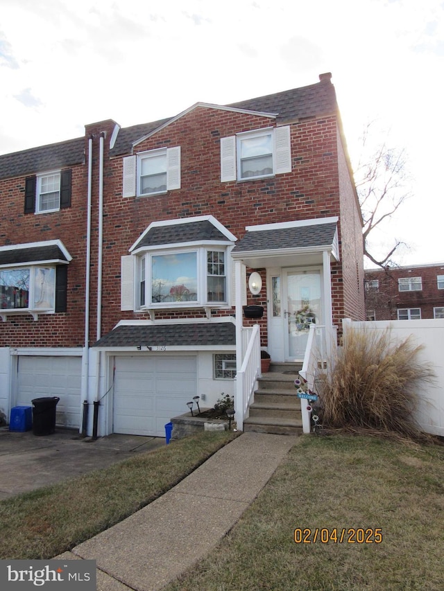 view of front of house featuring a garage and a front lawn