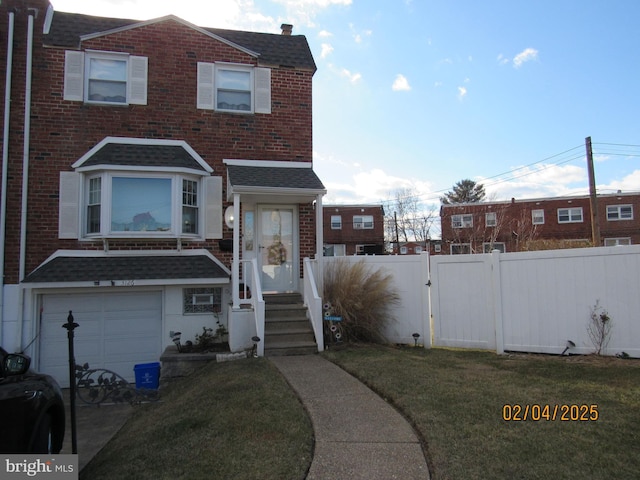 townhome / multi-family property featuring a garage and a front yard