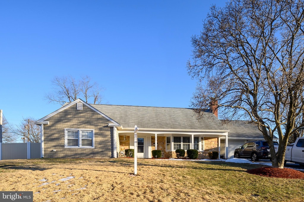 ranch-style house featuring a garage, a front yard, and a porch