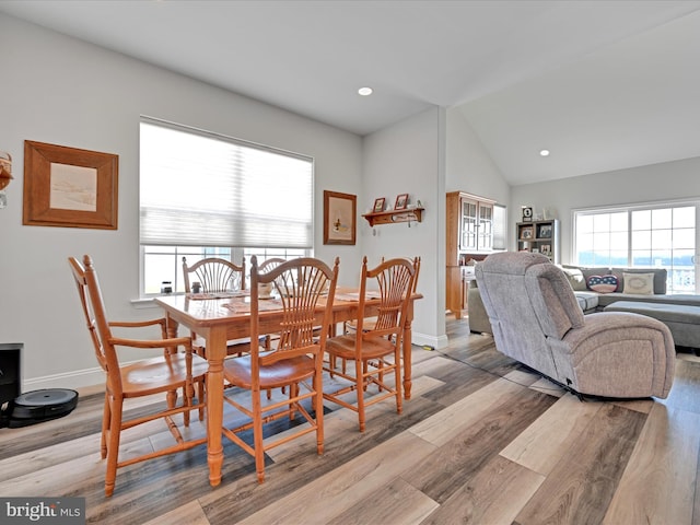 dining room featuring vaulted ceiling and light hardwood / wood-style floors