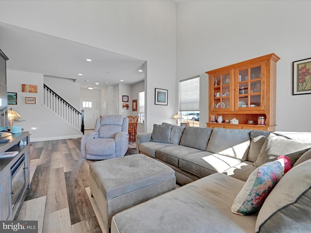 living room featuring hardwood / wood-style flooring and a towering ceiling