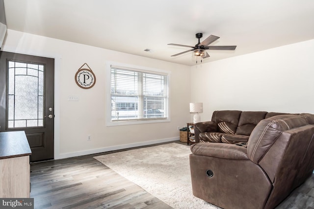 living room featuring dark hardwood / wood-style floors and ceiling fan