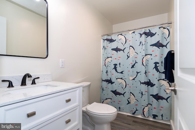 bathroom with wood-type flooring, curtained shower, vanity, and toilet