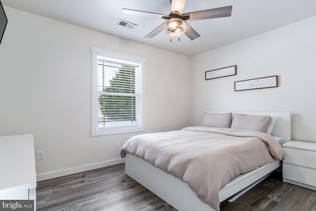 bedroom with dark hardwood / wood-style flooring and ceiling fan