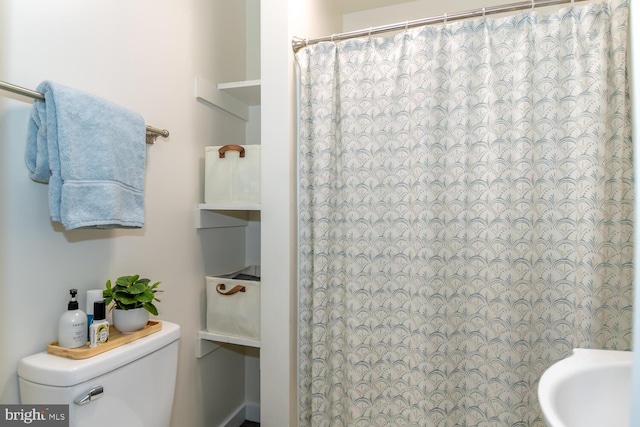 bathroom with curtained shower and toilet