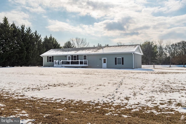 snow covered house with a wooden deck