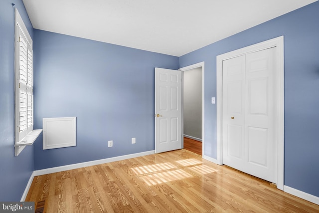 unfurnished bedroom with a closet and light hardwood / wood-style floors