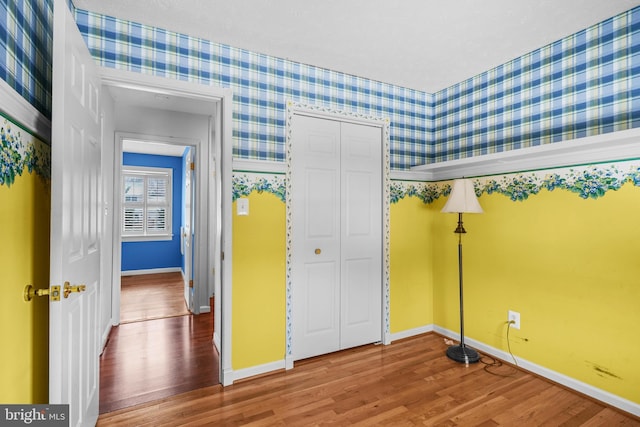 unfurnished bedroom with wood-type flooring and a closet