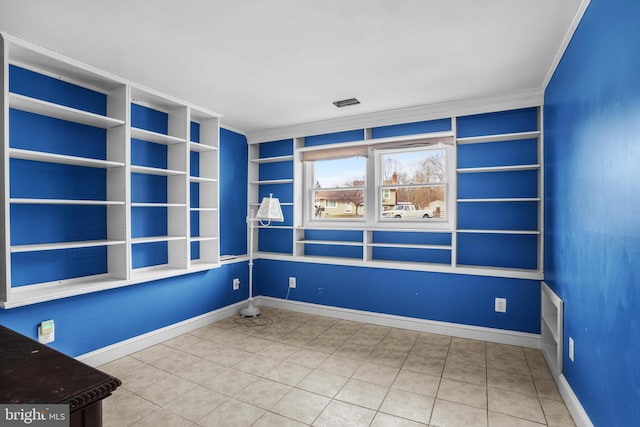 empty room featuring built in shelves and ornamental molding